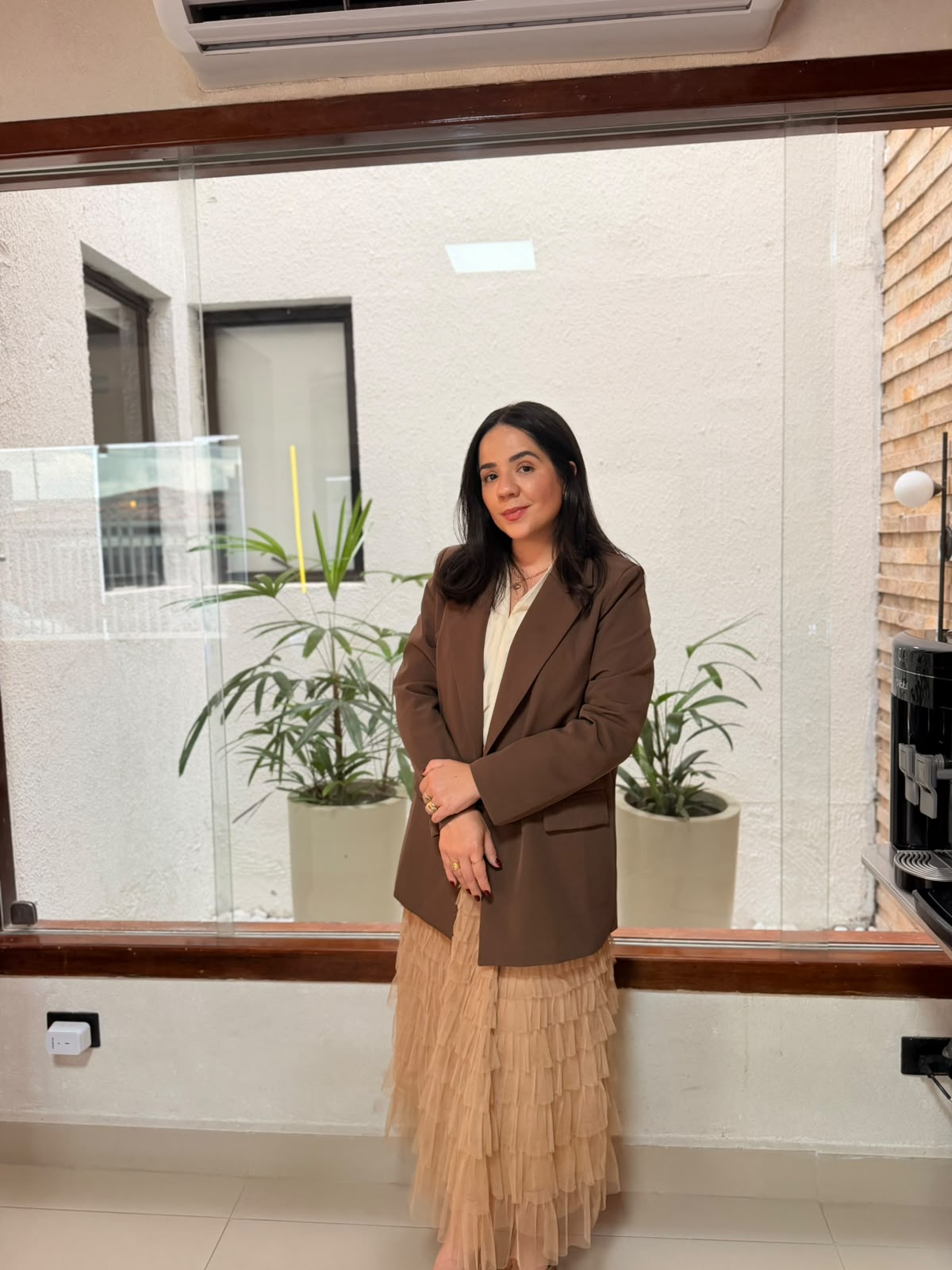 Recepção da clínica com balcão e parede de vidro